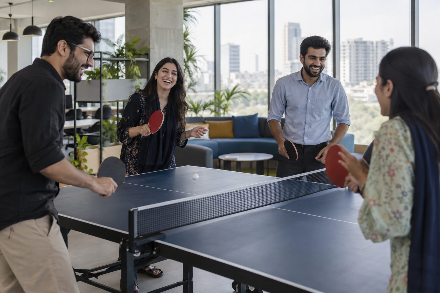 colleagues laughing around a table tennis table in the office